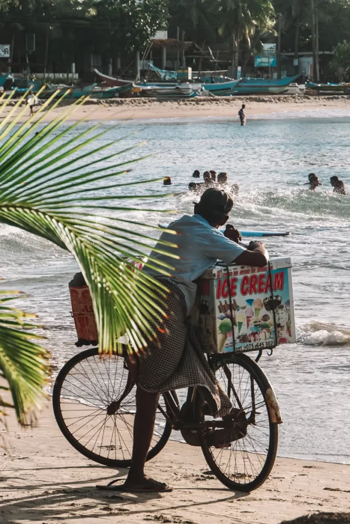 A man selling ice cream from a push bike on Arugam Bay beach
