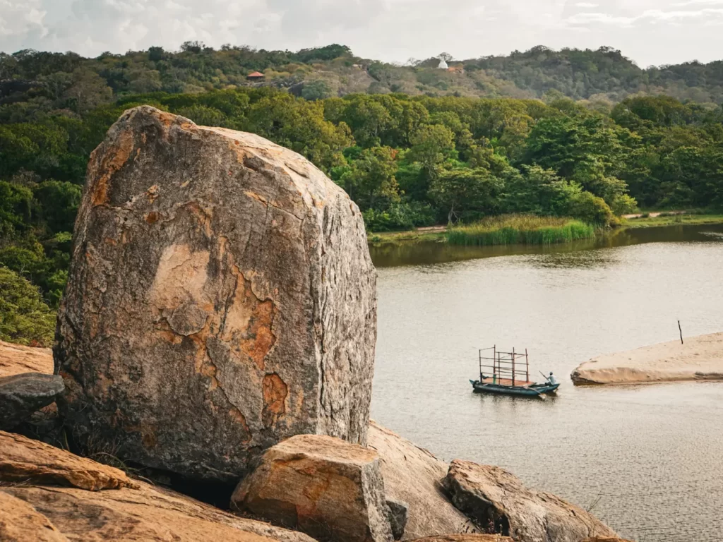 A man is paddling a gondola to get across the lagoon to the beach at Elephant Rock
