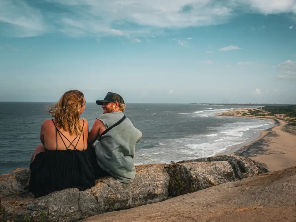 A couple sit smiling at each other at the top of Elephant Rock facing south to Peanut Farm