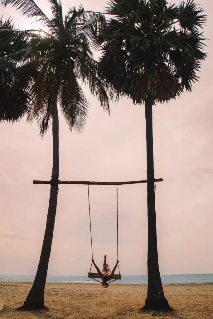A girl swings on the beachfront swing at Jetwing surf