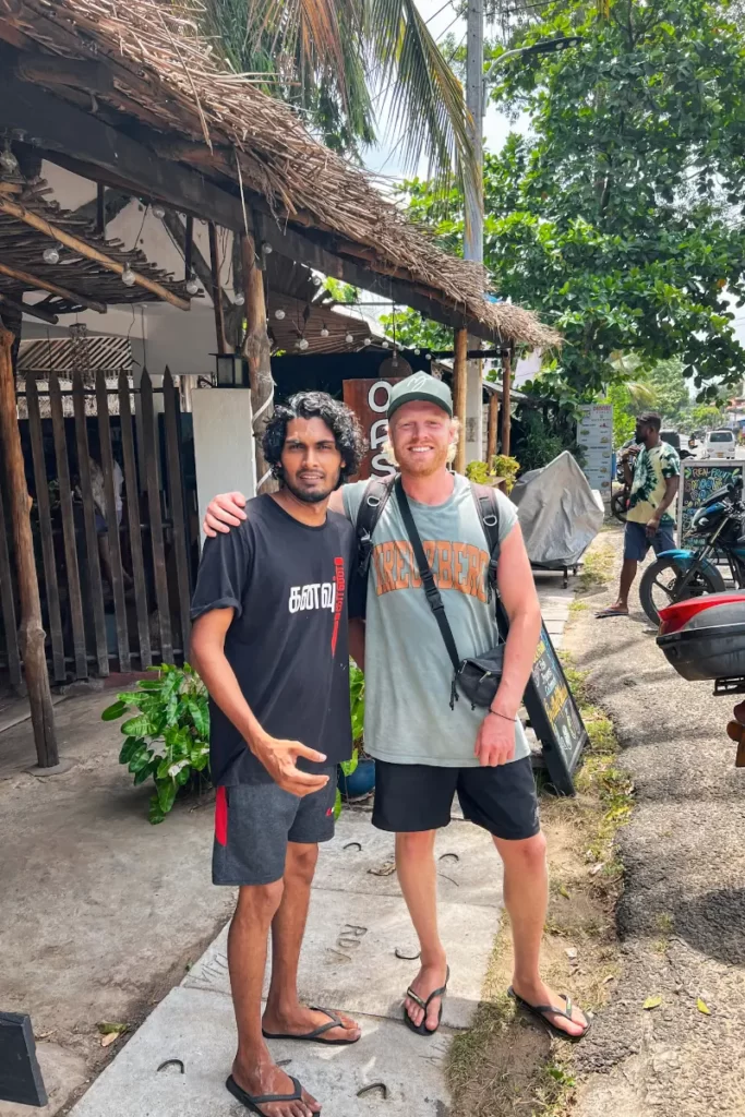 A traveller and a local posing for a picture outside of Oasis Bay Arugam Bay