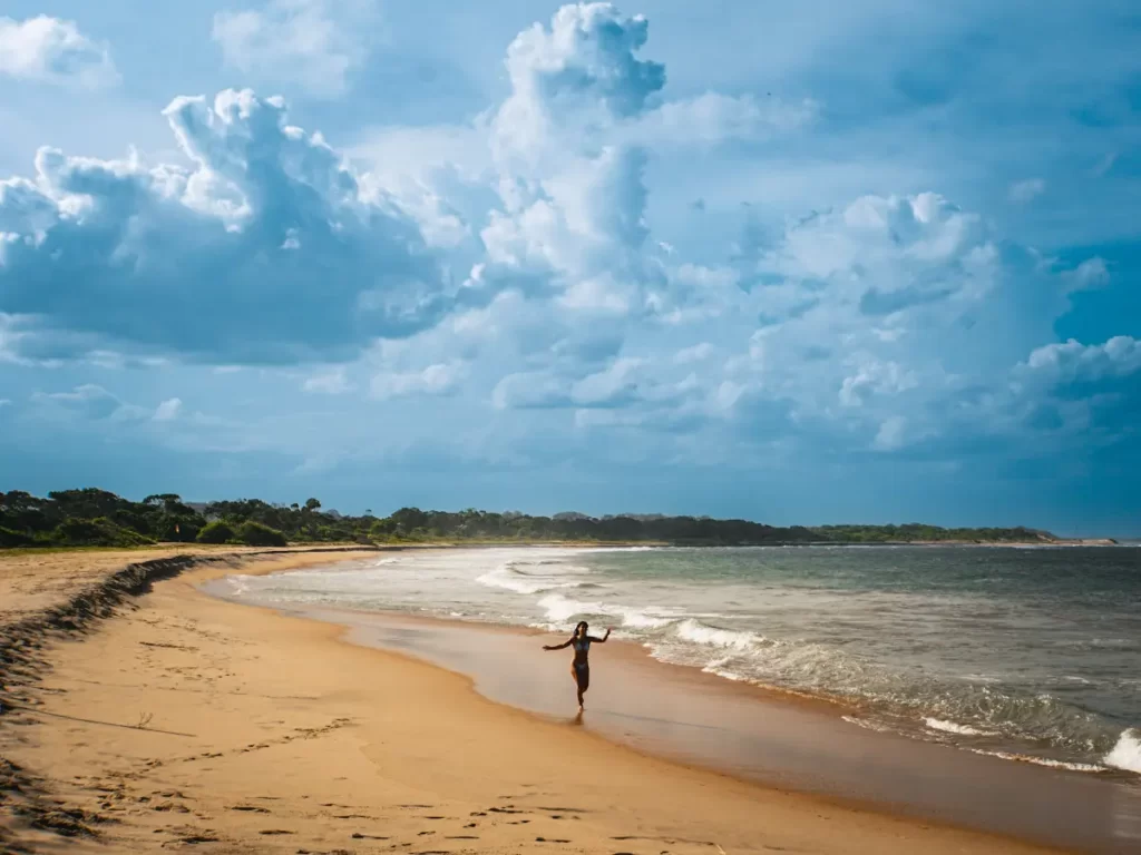 A girl runs down the beach at Peanut Farm near Arugam Bay