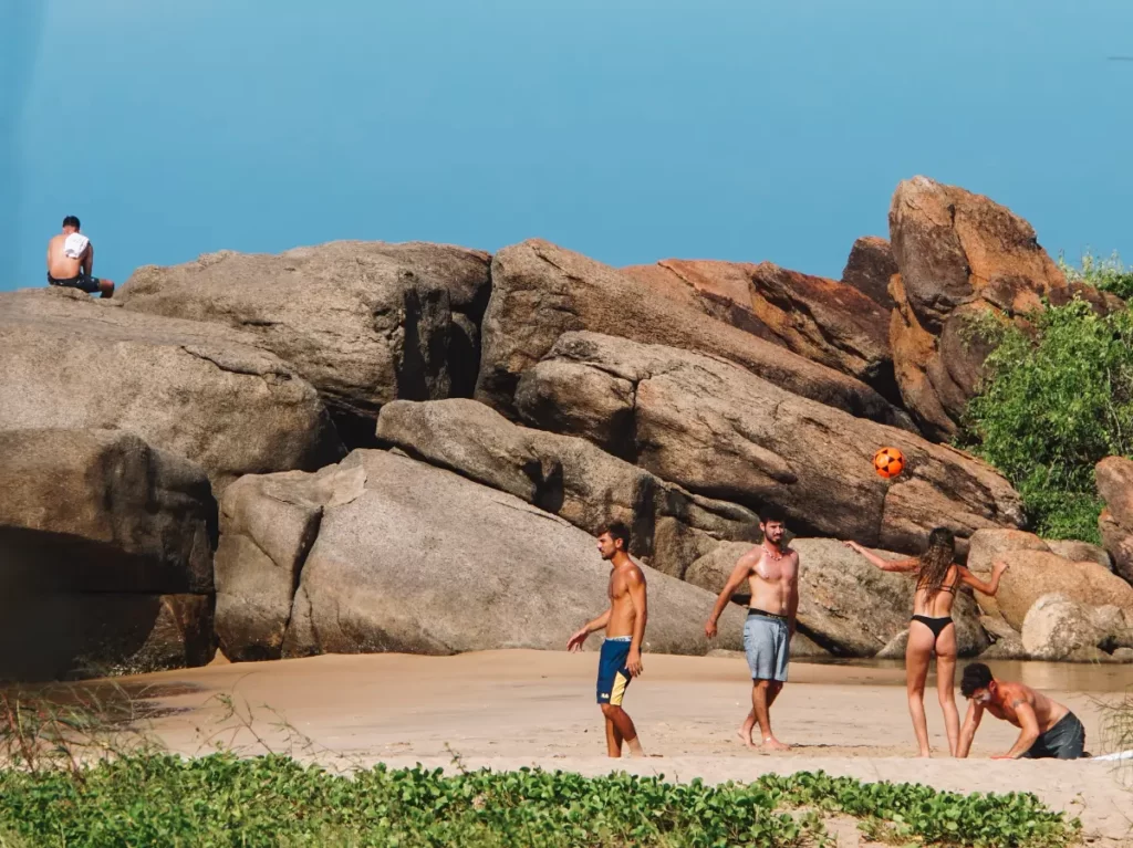 A group of travellers playing volleyball at Peanut Farm Beach