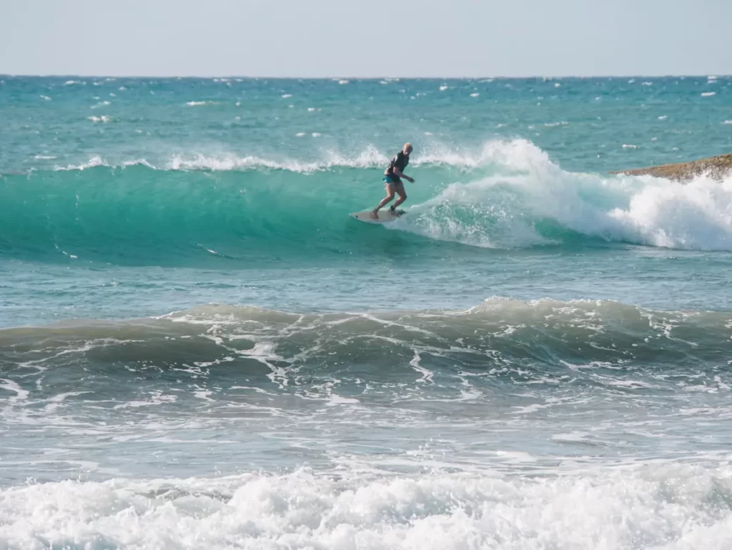 A man surfing at Lighthouse Point opposite Hilltop Cabanas beach