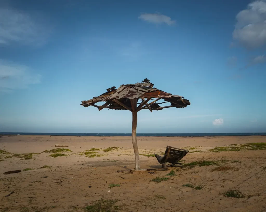 A old makeshift wooden parasol and chair standing on it own on Elephant Rock Beach