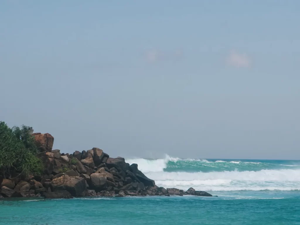 The gas stations surf spot big wave turning into calm past the rock headland