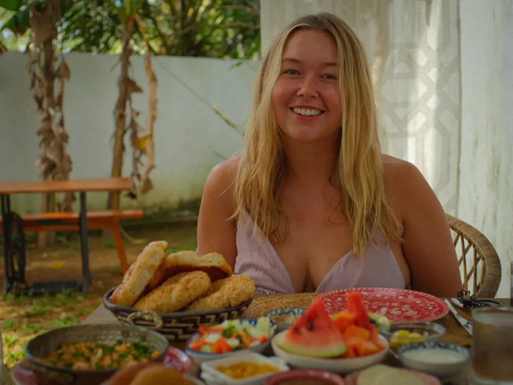 A girl smiling with her Turkish Breakfast at Sisters Away