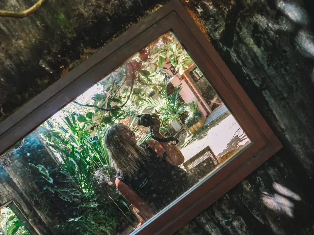 A girl takes a picture of herself in a mirror in Trax restaurants garden