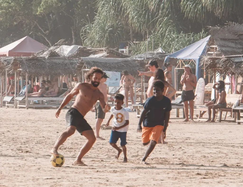 Travellers playing football with the local kids on Kabalana Beach
