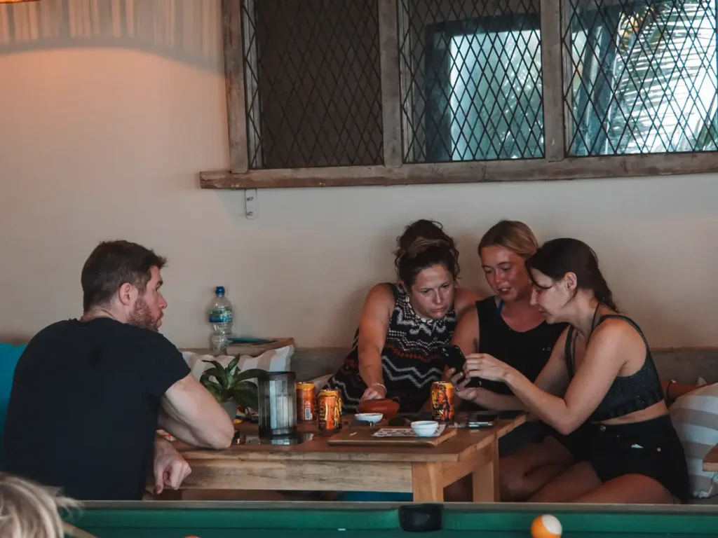 A group of travelers have beers and chat in a bar in Ahangama