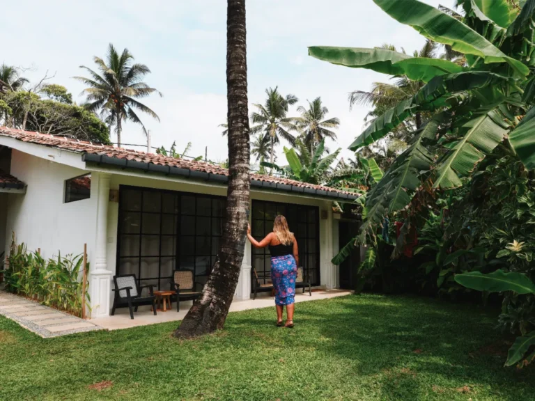 A girl stands against a tree looking a the Surf lodge rooms
