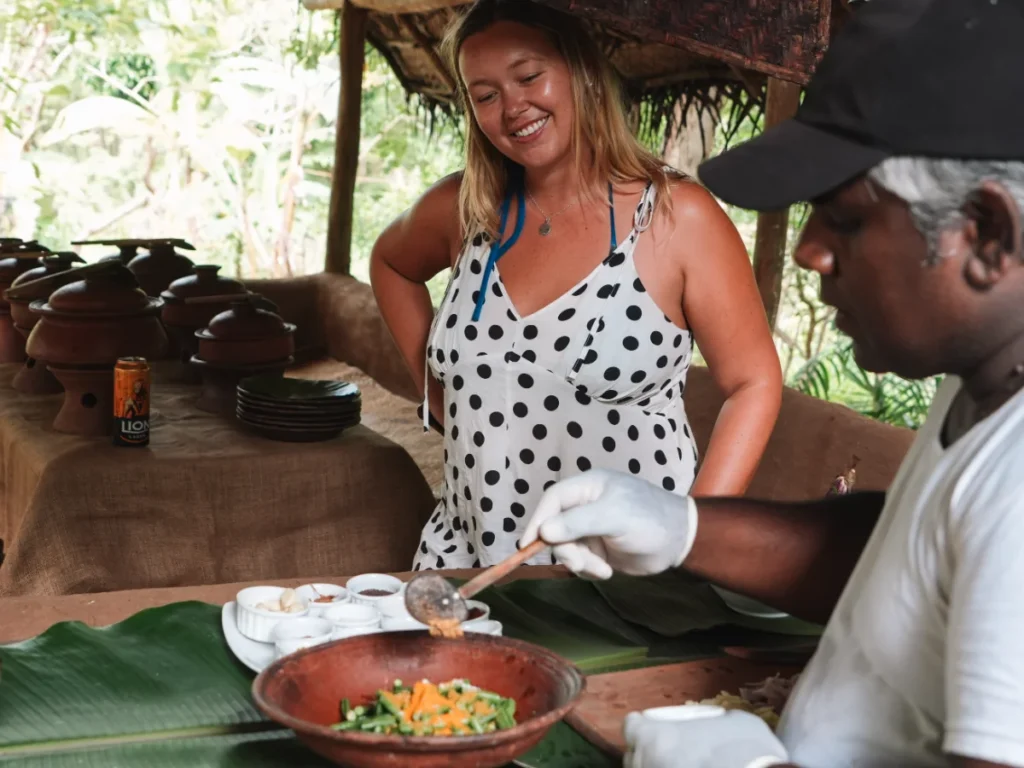 A girl watches a local chef cook rice and curry on a village tour in Sigiriya
